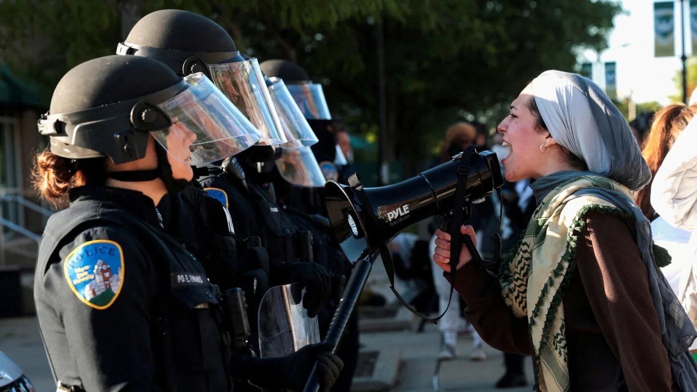 A pro-Palestinian protester faces off with Wayne State University police after a student encampment was raided by police in Detroit, Michigan, 30 May 2024 (Reuters/Rebecca Cook)