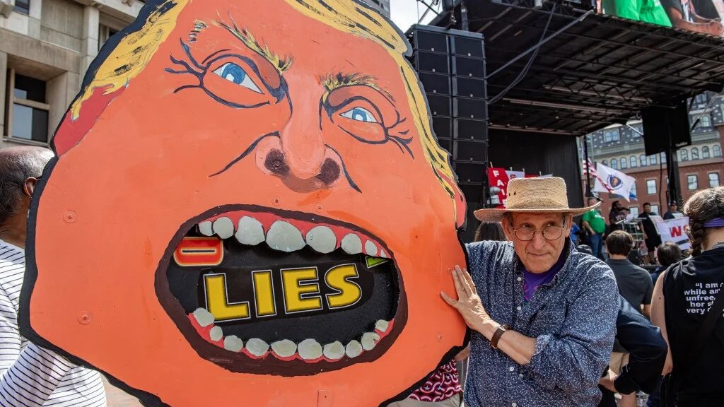 A person carries a giant caricature of US President Donald Trump during a rally in Boston, Massachusetts, on 1 September 2025 (Joseph Prezioso/AFP)