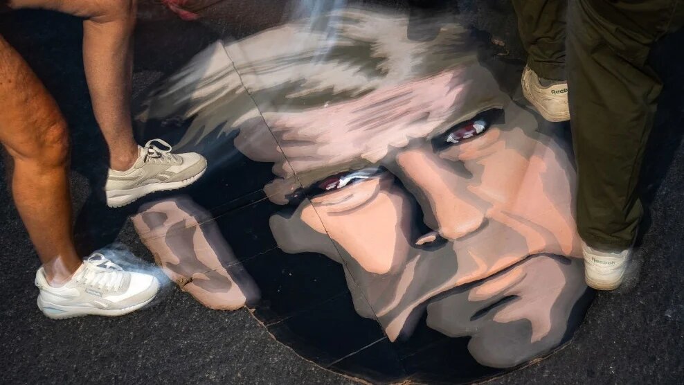 Protesters stomp on a cardboard cutout of the face of US President Donald Trump near the White House in Washington, DC, on 7 July 2025 (Kent Nishimura/Getty Images/AFP)