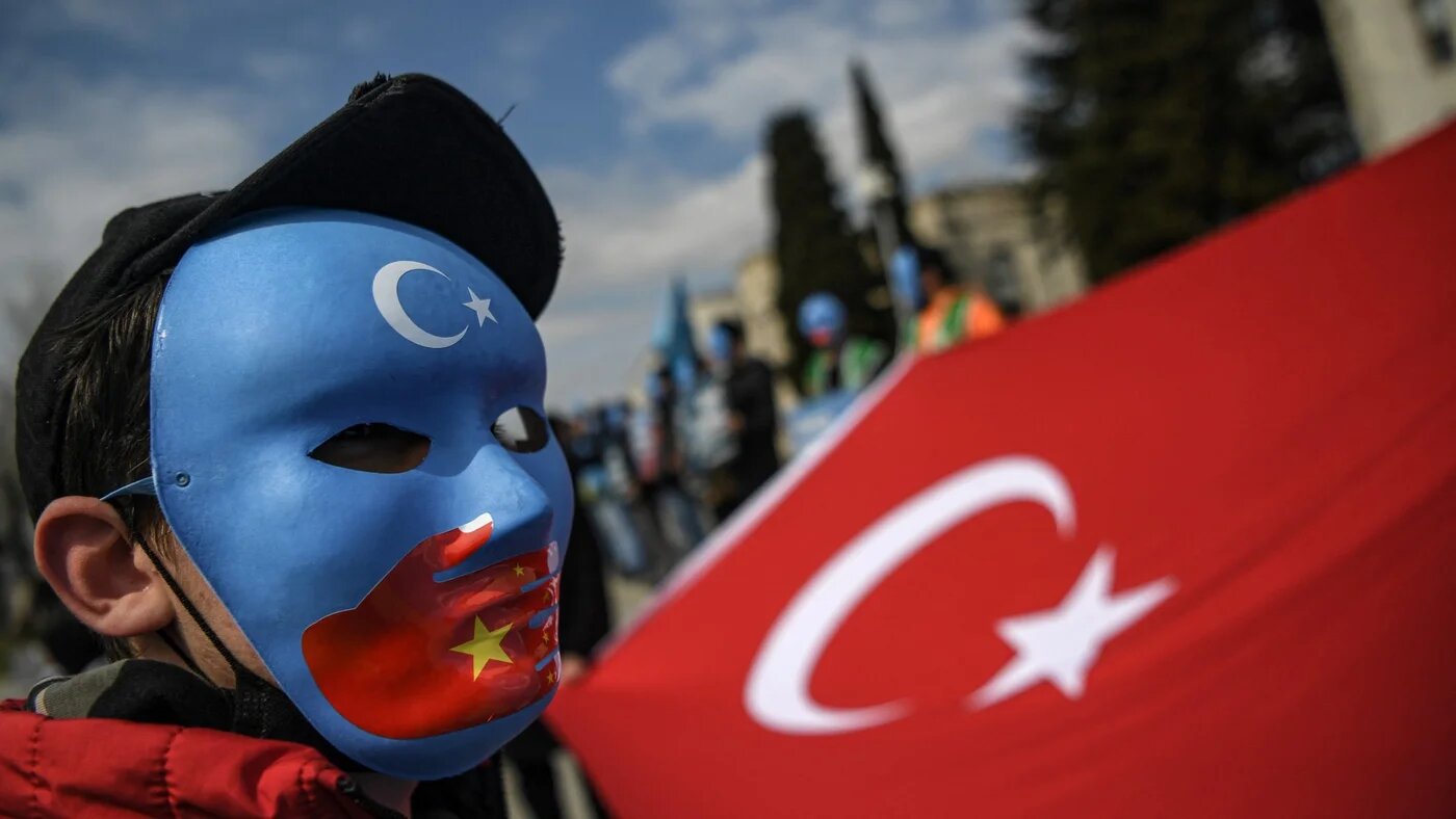 A demonstrator wears a mask painted with the colours of East Turkestan's flag at a protest by supporters of the Uyghur minority at Beyazid Square in Istanbul on 1 April 2021 (Ozan Kose/AFP)
