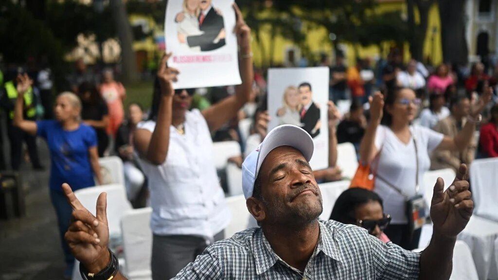 An Evangelical man prays during an event in support of deposed Venezuelan president Nicolas Maduro and his wife Cilia Flores, at Plaza Bolivar in Caracas on 11 January 2026 (AFP)