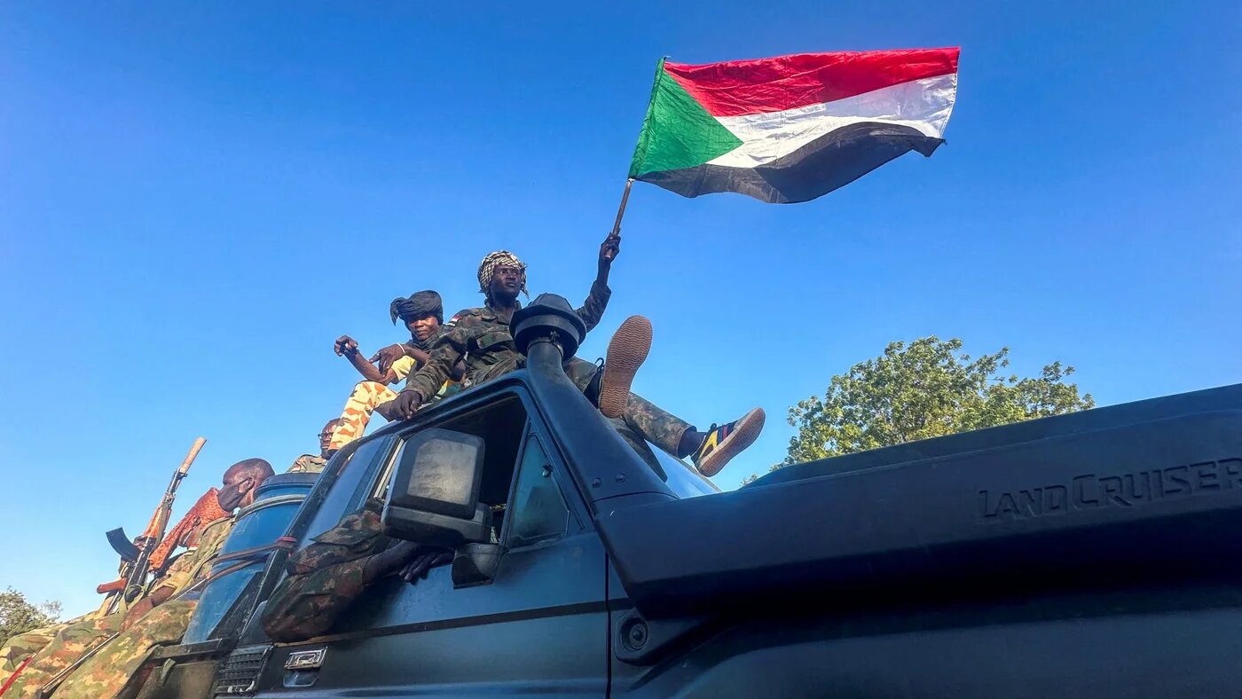 Sudan's army soldiers celebrate after entering Wad Madani, in Sudan, 12 January (Reuters/El Tayeb Siddig)