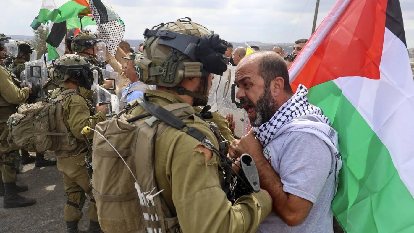 A Palestinian demonstrator confronts Israeli security forces during a protest against the expropriation of Palestinian land by Israel in the village of Kfar Qaddum on October 7, 2022 (AFP)