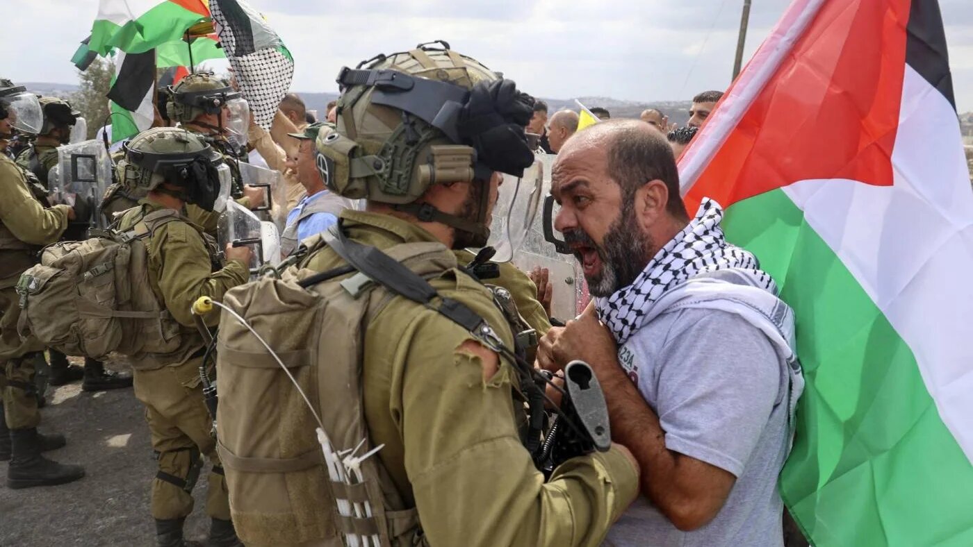 Un manifestant palestinien affronte les forces de sécurité israéliennes lors d’une manifestation contre l’expropriation de terres palestiniennes par Israël dans le village de Kfar Qaddum en Cisjordanie occupée près de la colonie juive de Kedumim, le 7 octobre 2022 (AFP/Jaafar Ashtiyeh)