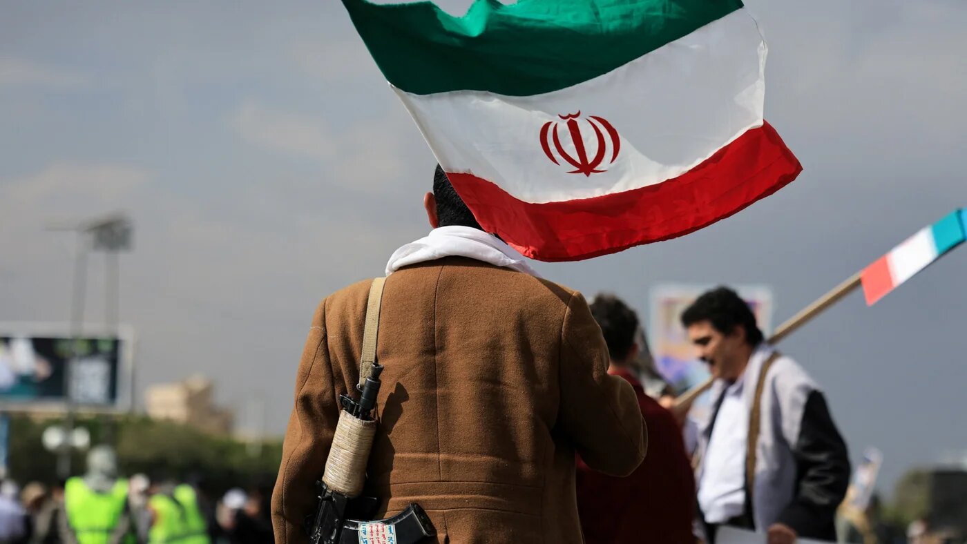 A person walks with an Iranian flag during a protest against Israeli and the US strikes on Iran, following the killing of Supreme Leader Ali Khamenei, in Sanaa, 1 March 2026 (Reuters/Khaled Abdullah)