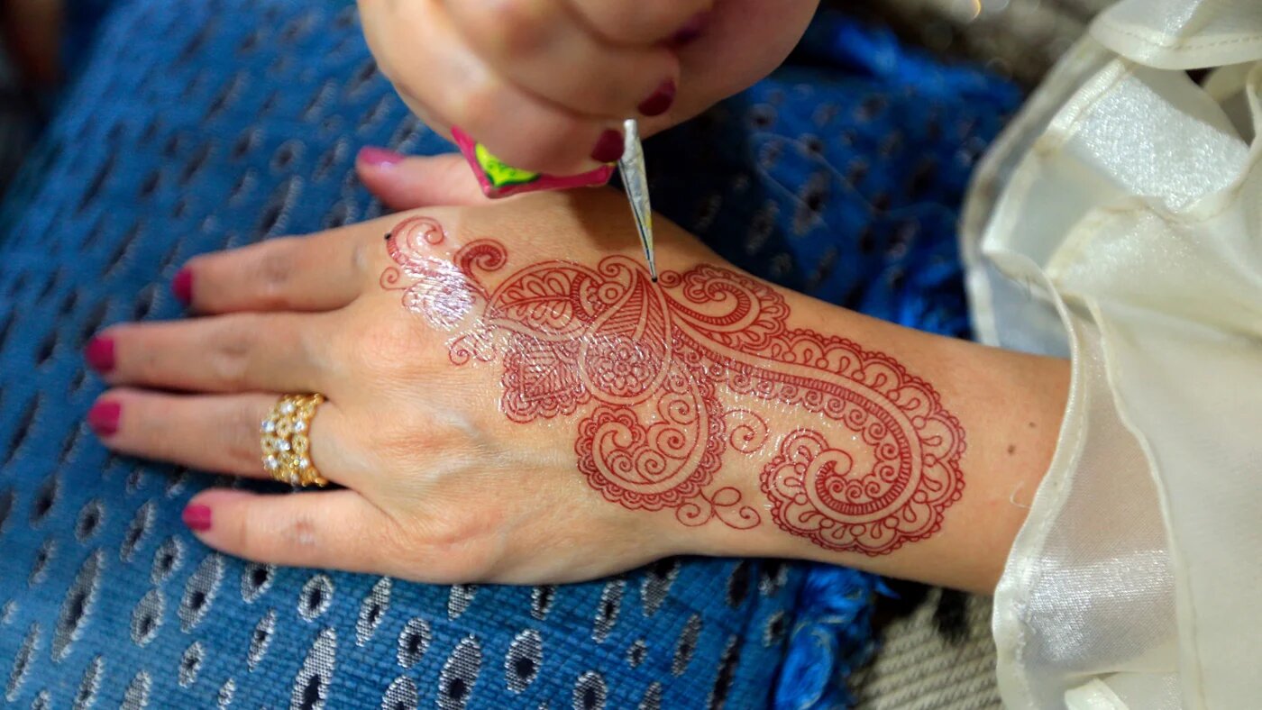 A Yemeni woman applies henna on her hand in Sanaa on 2 December 2024 (Mohammed Huwais/AFP)