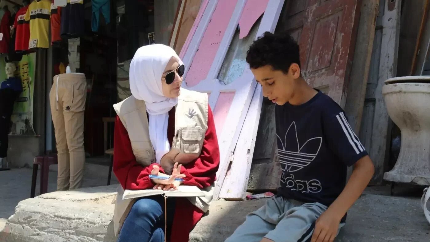 Maha Hussaini interviews a Palestinian boy in Gaza in June 2023 (Supplied/Mahmoud Mushtaha)