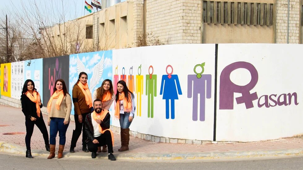 Activists from pro-LGBT group Rasan pose in front of murals in Sulemaniyah in 2018 (supplied)