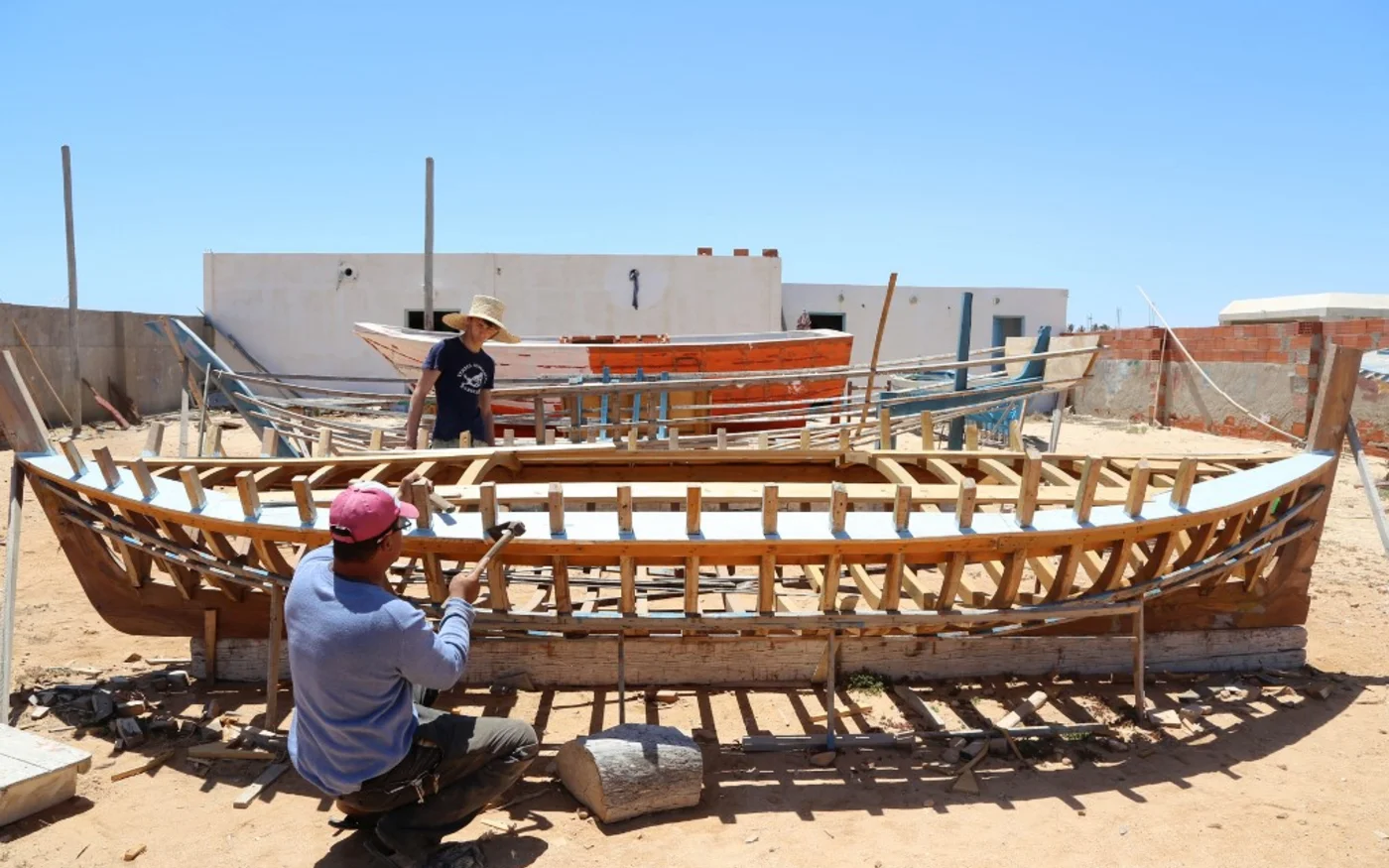 Un pêcheur de Kerkennah travaille sur sa barque en bois (AFP)
