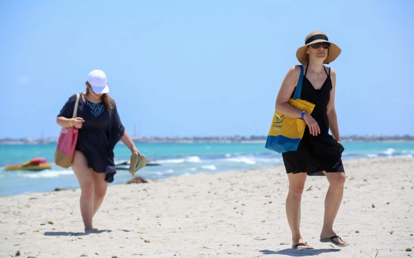 Des touristes européens se promènent à la plage d’un hôtel de l’île de Djerba le 18 juillet 2020 (AFP)