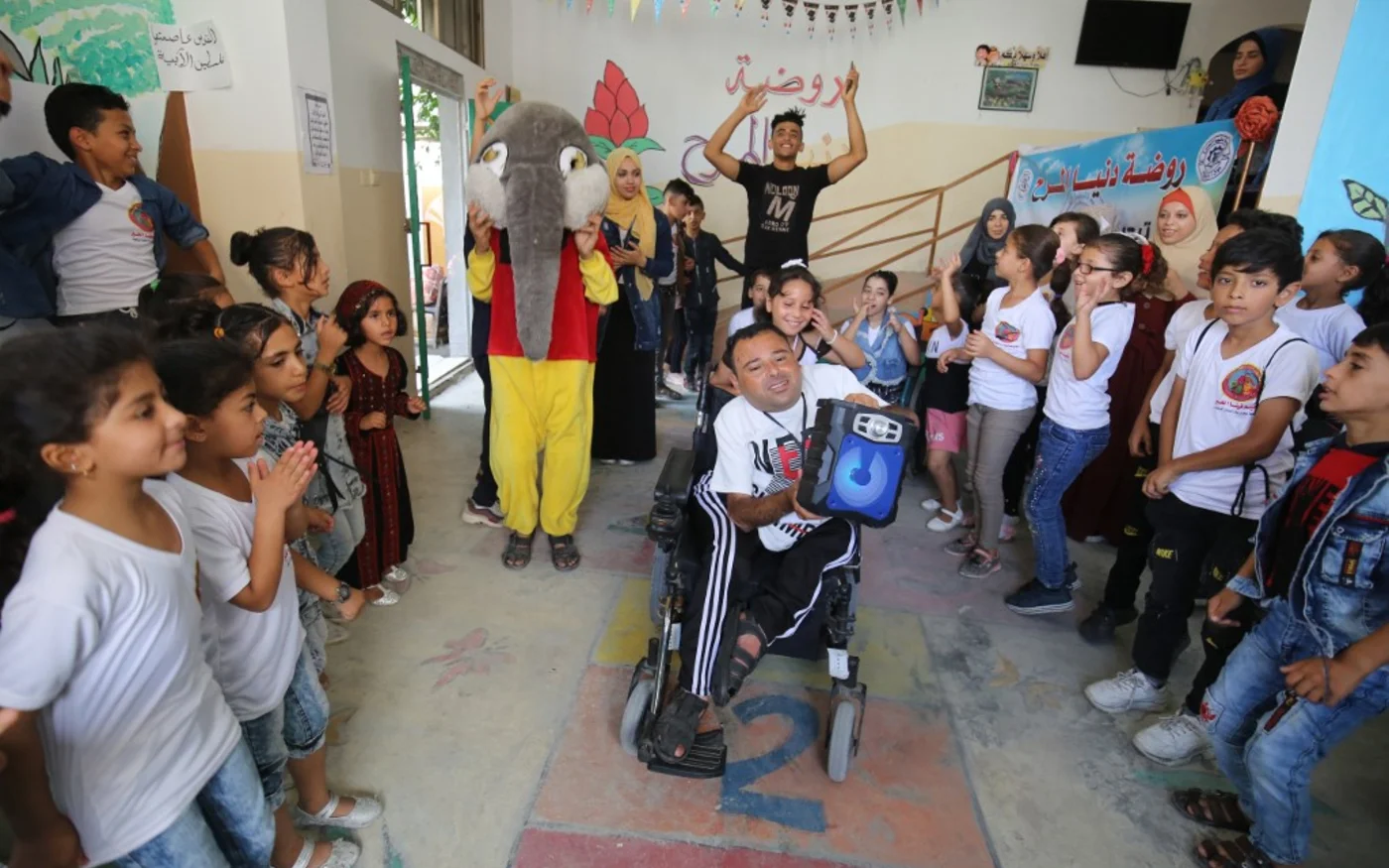 Nihad Jarboa, 37 ans, entouré par des enfants et des bénévoles (AFP) 
