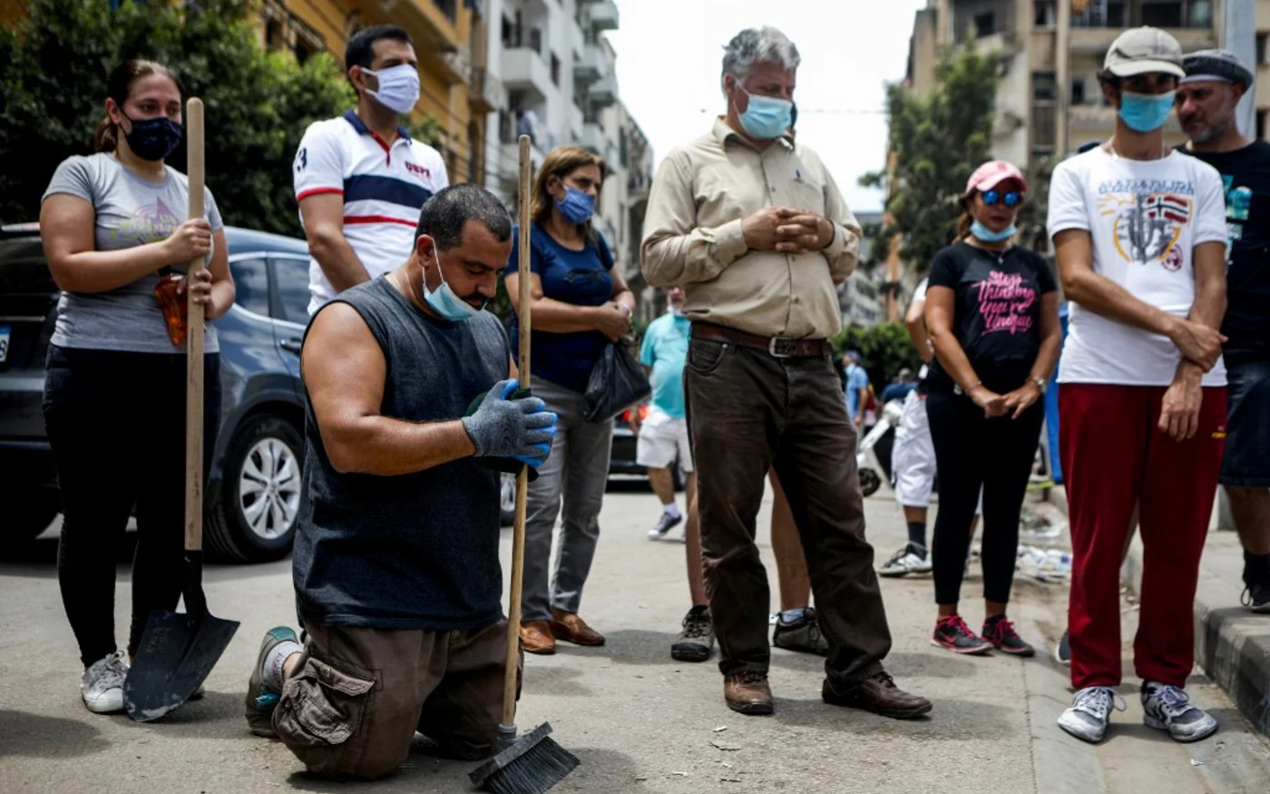 Des volontaires et des membres de la société civile assistent à une messe dominicale en plein air dans le quartier Mar Mikhael de la capitale libanaise Beyrouth le 9 août 2020 (AFP)
