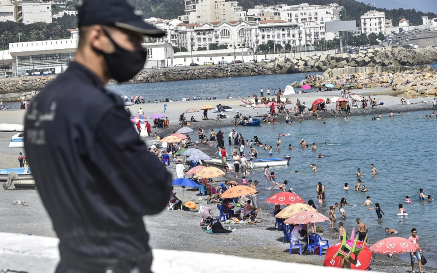 Un policier face à la plage d’El-Kettani, dans le quartier de Bab el Oued à Alger, le 15 août 2020 (AFP)