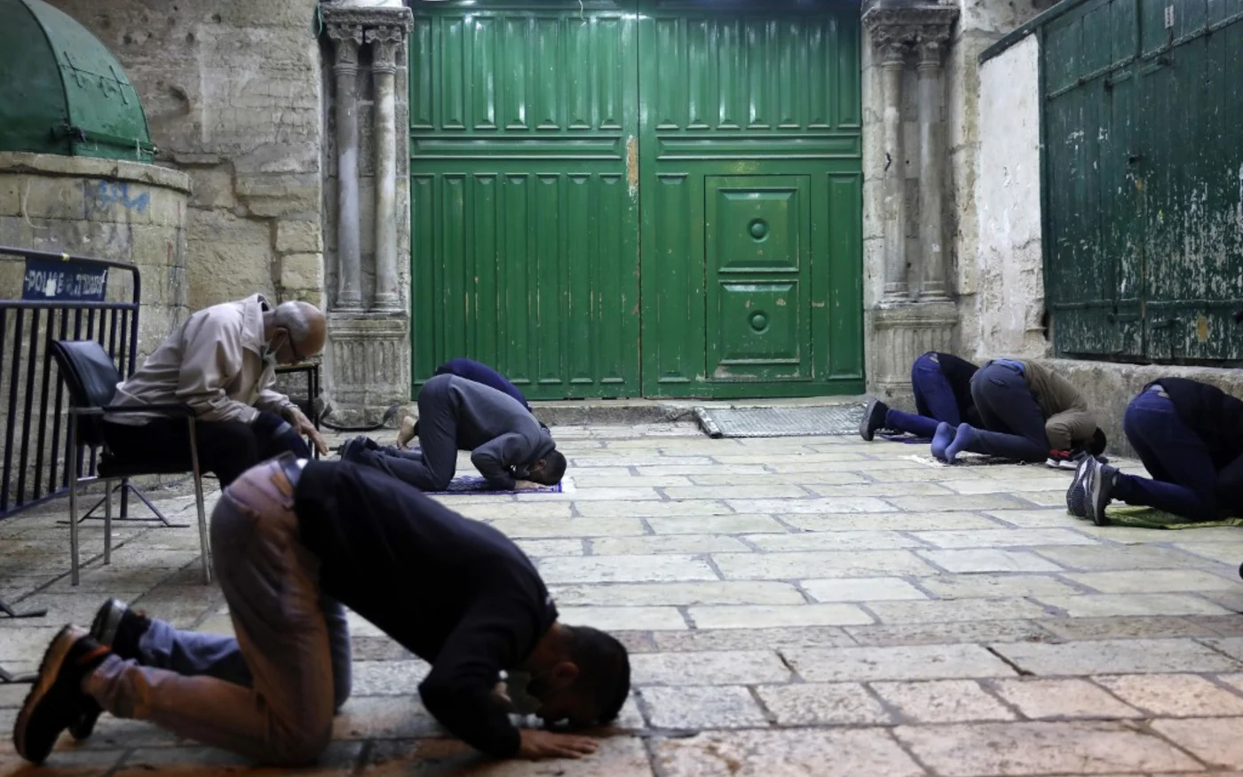 Des fidèles palestiniens font la prière à l’extérieur de l’esplanade des Mosquées à Jérusalem, le 27 avril 2020 (AFP)