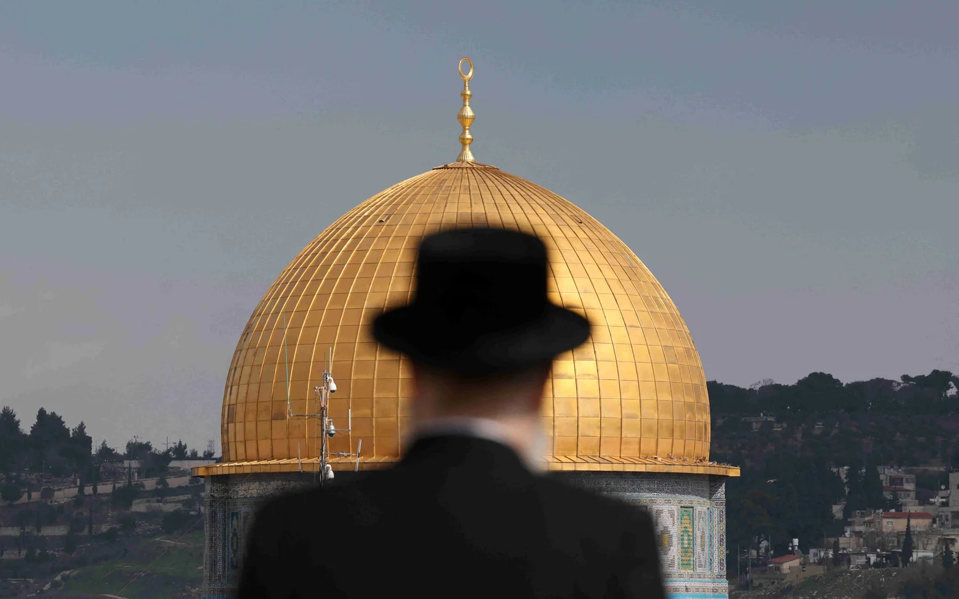 Un juif ultra-orthodoxe dans le quartier juif de la vieille ville de Jérusalem surplombant le dôme du Rocher du complexe de la mosquée al-Aqsa, le 12 février 2023 (AFP)