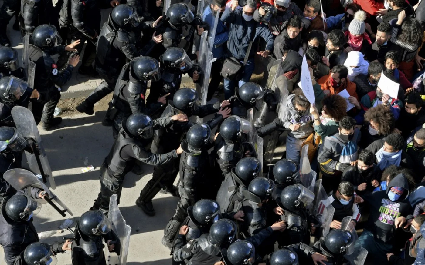 Les forces de l’ordre tunisiennes tentent de bloquer l’avancée des manifestants, à Tunis, le 26 janvier 2021 (AFP/Fethi Belaid)