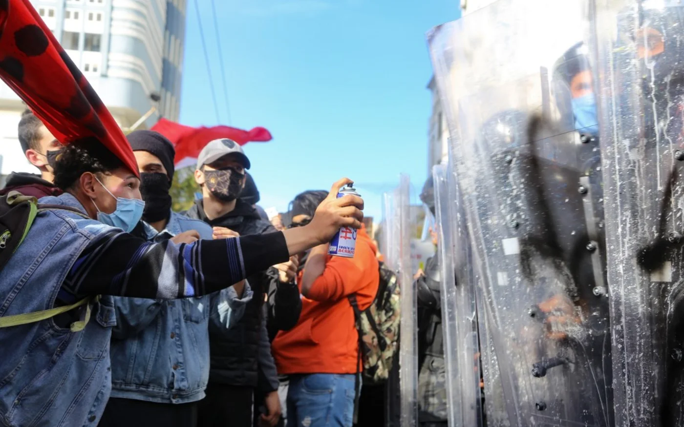 Un jeune Tunisien tague le bouclier d’un policier, lors de la manifestation du samedi 30 janvier, à Tunis, contre la répression policière AFP)