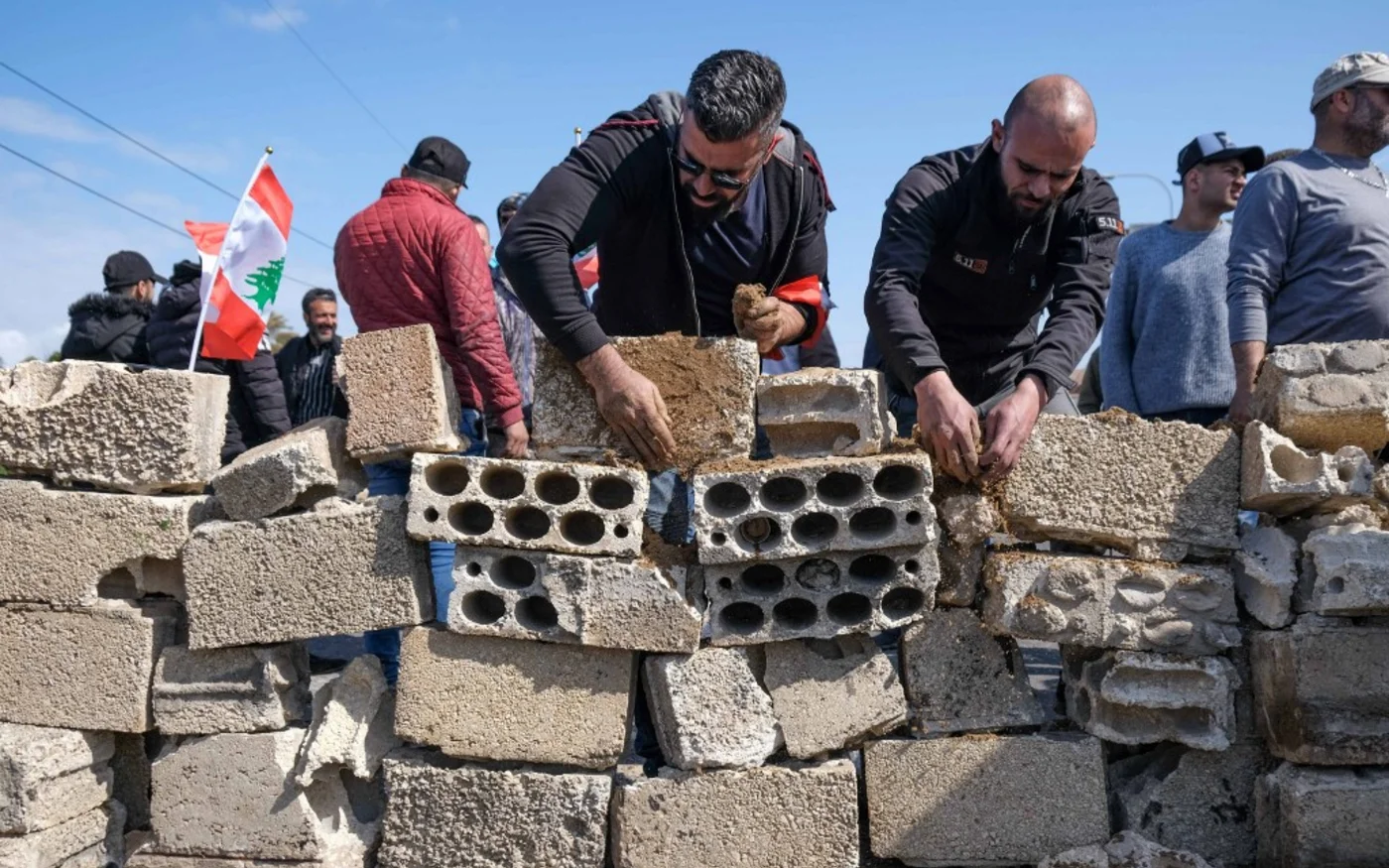 Des manifestants construisent un mur pour fermer l’autoroute à l’entrée sud de Tripoli, le 8 mars 2021 (AFP)