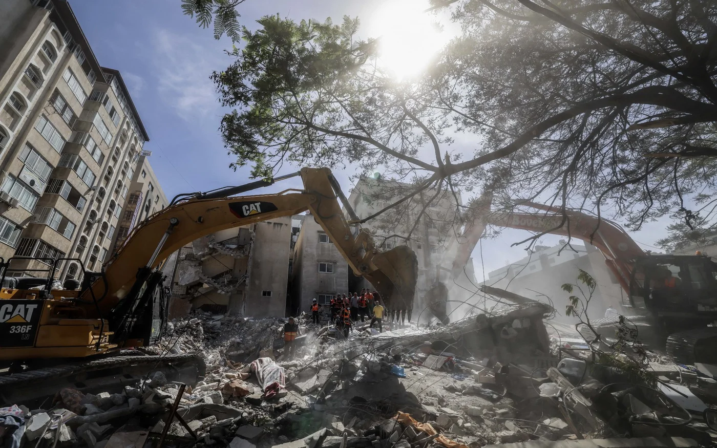 Une pelleteuse dégage les décombres d’un bâtiment détruit dans le quartier résidentiel al-Rimal de Gaza après une frappe aérienne israélienne, le 16&nbsp;mai&nbsp;2021 (AFP)