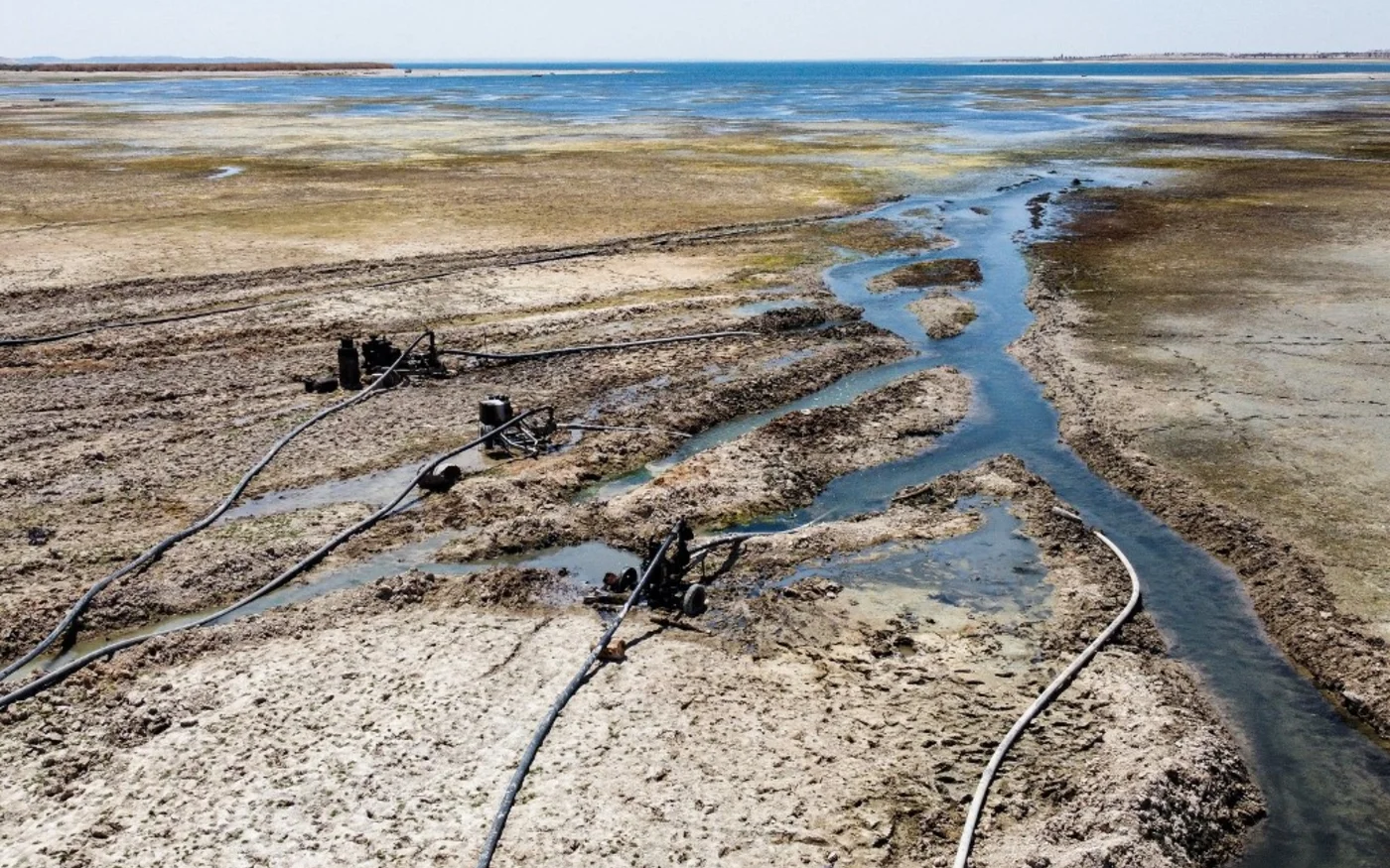 Cette photo prise le 27 juillet 2021 montre des pompes à eau puisant de l’eau dans le réservoir du lac Assad asséché, le long de l’Euphrate dans la province de Raqqa, en Syrie (AFP/Delil Souleiman)