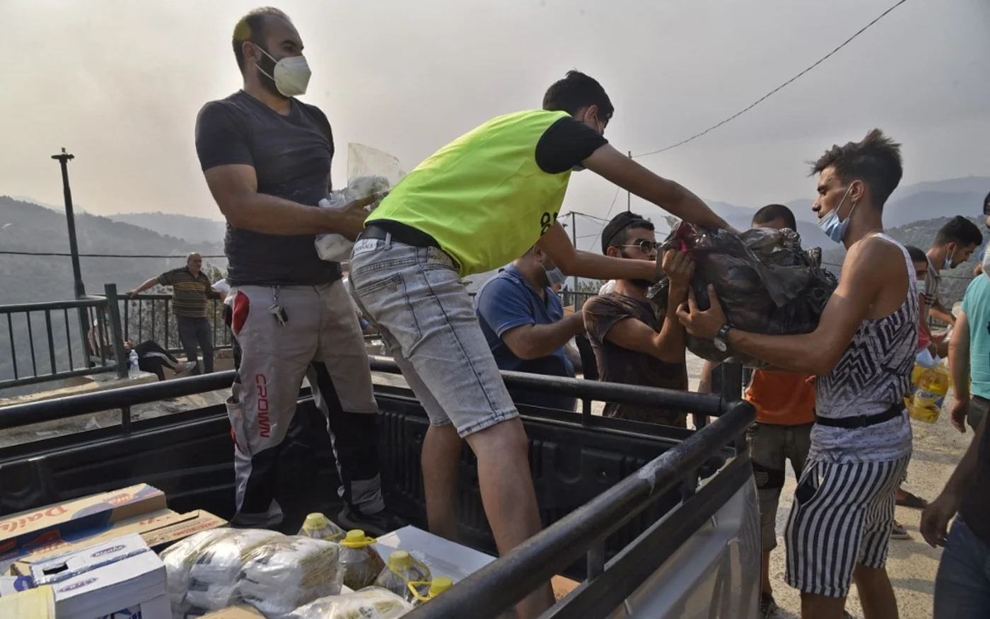 Des villageois en Kabylie reçoivent des dons envoyés d’autres régions (AFP/Ryad Kramdi)