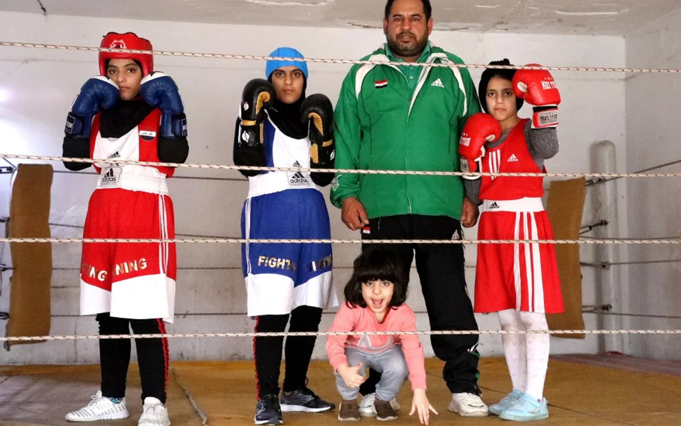 Un entraîneur de boxe pose avec ses élèves dans la ville d’Amara, dans la province de Maysan, dans le sud-est de l’Irak, le 19 décembre 2021 (AFP/Asaad Niazi) 