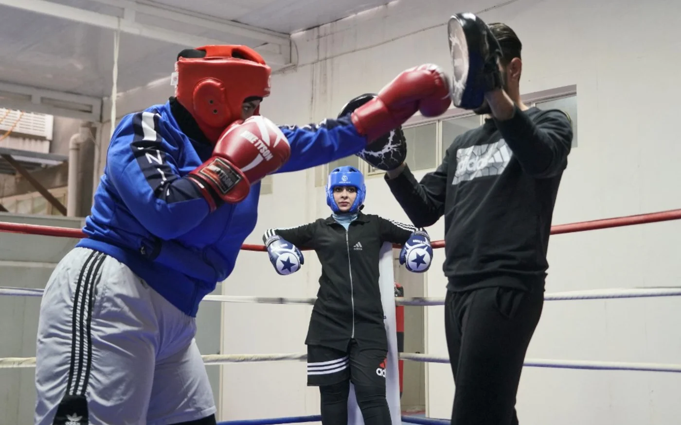 Bouchra al-Hajjar observe l’entrainement de Ola Moustapha, 16 ans, dans une salle de l’Université islamique de Nadjaf, le 14 décembre 2021 (AFP/Qassem al-Kaabi)
