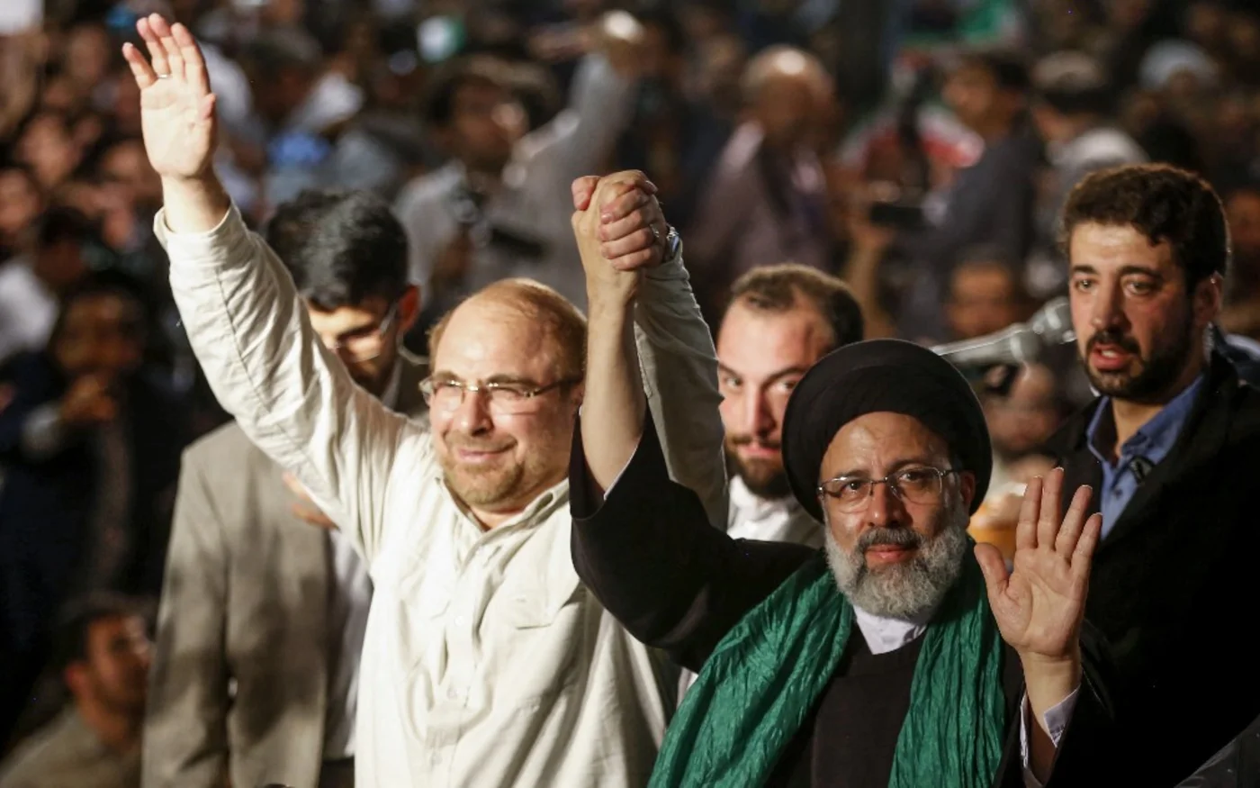 Ebrahim Raïssi (à&nbsp;droite) tient la main de Mohammad Bagher Ghalibaf, ancien candidat à la présidence et maire de Téhéran, lors d’un meeting de campagne à Téhéran, le 16&nbsp;mai&nbsp;2017 (AFP)
