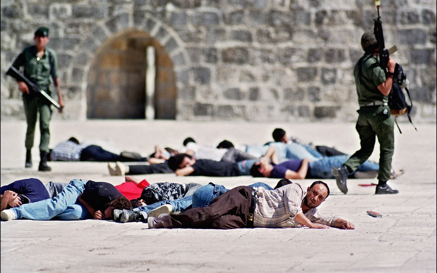 Des policiers israéliens se tiennent près de Palestiniens arrêtés après des manifestations à la mosquée al-Aqsa, dans la vieille ville de Jérusalem, le 8 octobre 1990 (AFP)