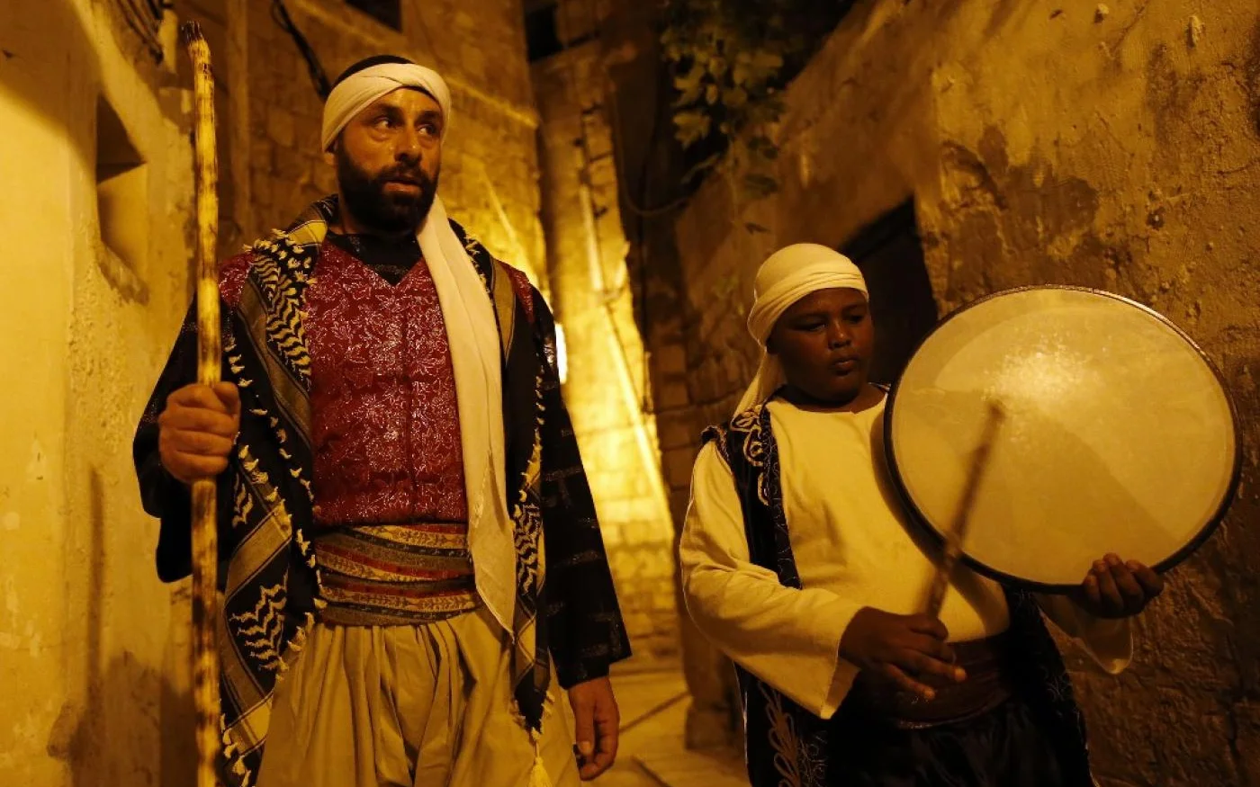 Un homme marche dans la rue pour réveiller les habitants du quartier et les inviter à manger et à prier (AFP)