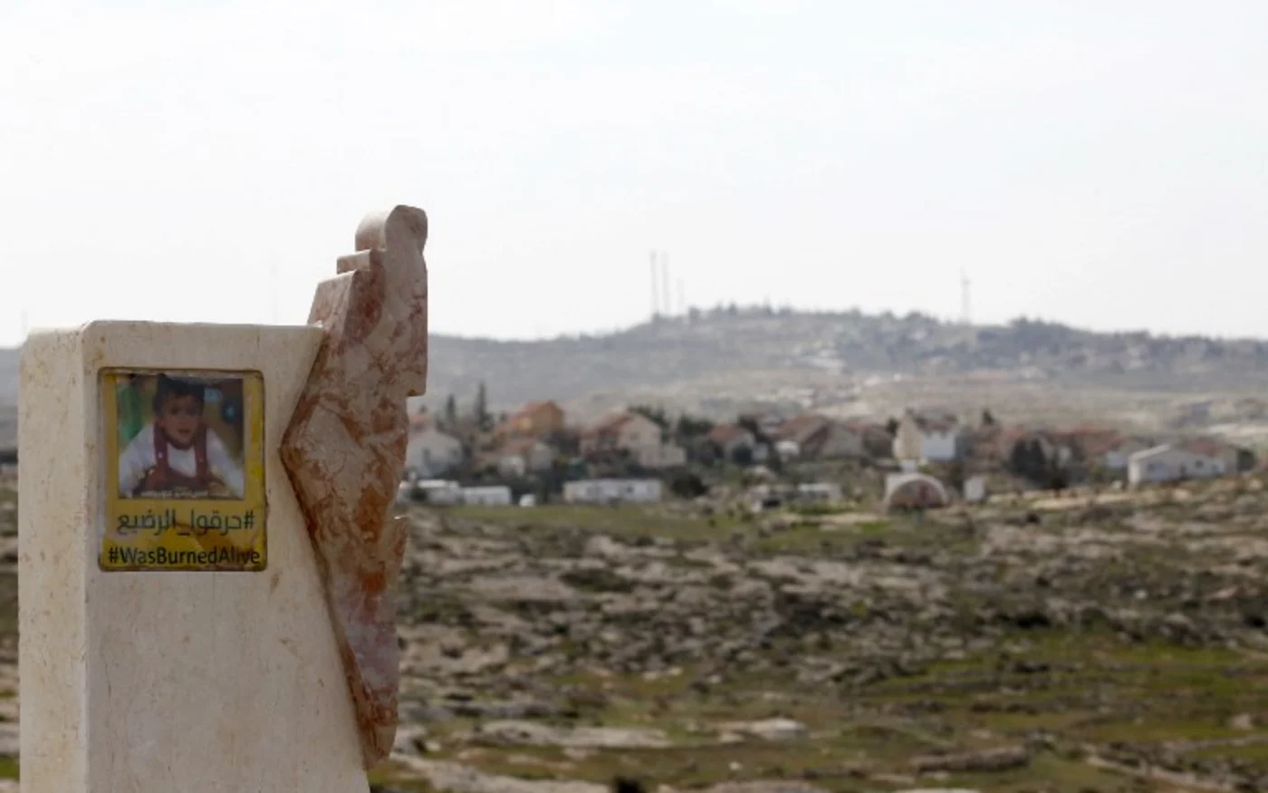 Une affiche arbore le portrait d’Ali Dawabsheh, un bébé palestinien tué dans une attaque incendiaire près de Hébron, en 2015 (AFP)