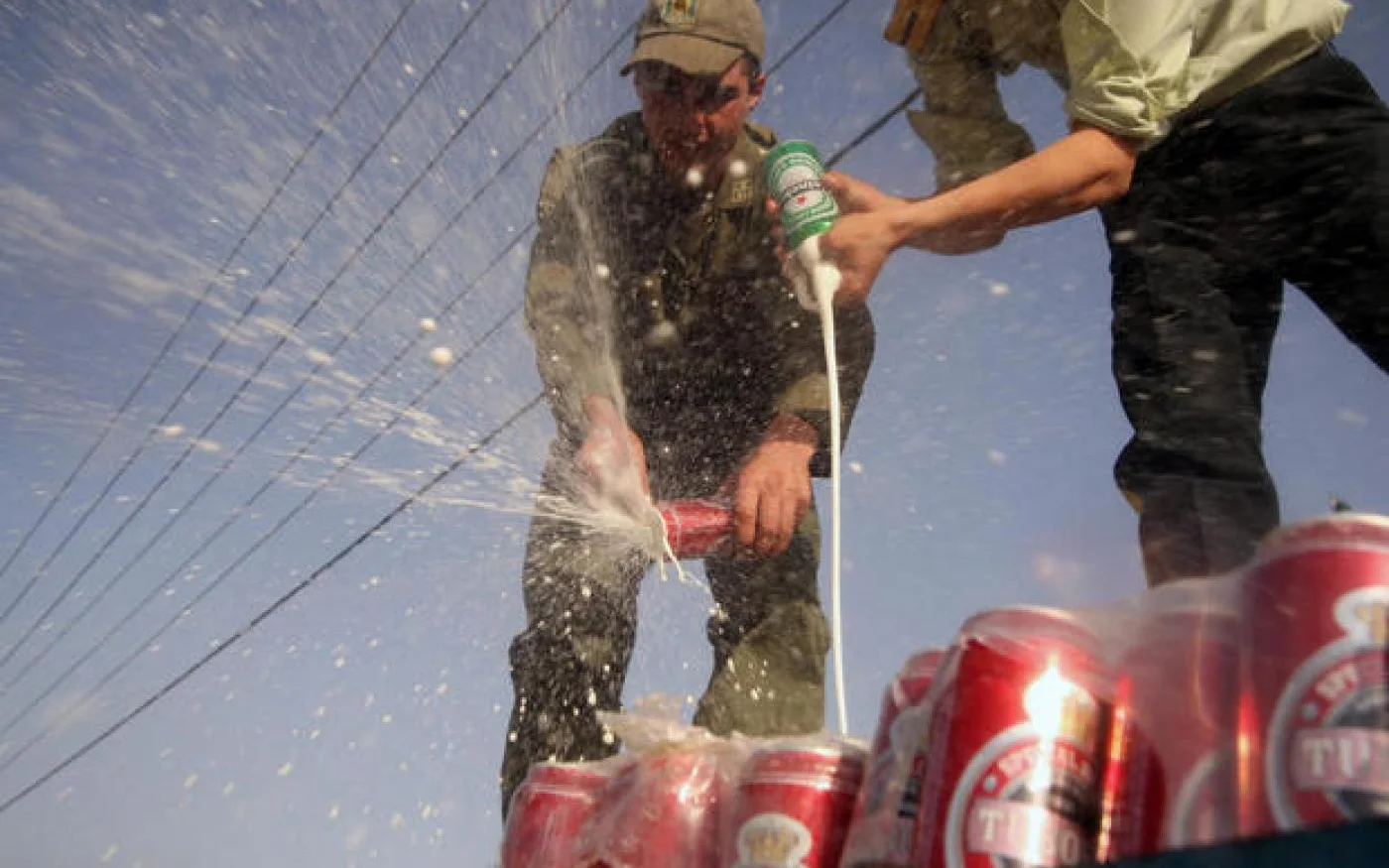 Des policiers iraniens se débarrassent de caisses d’alcool récupérées lors d’une saisie en 2016 (AFP)