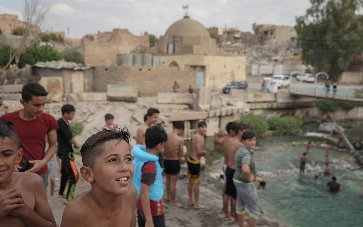 Des enfants irakiens nagent dans la rivière dans la ville dévastée de Tal Afar en septembre&nbsp;2019 (Reuters)