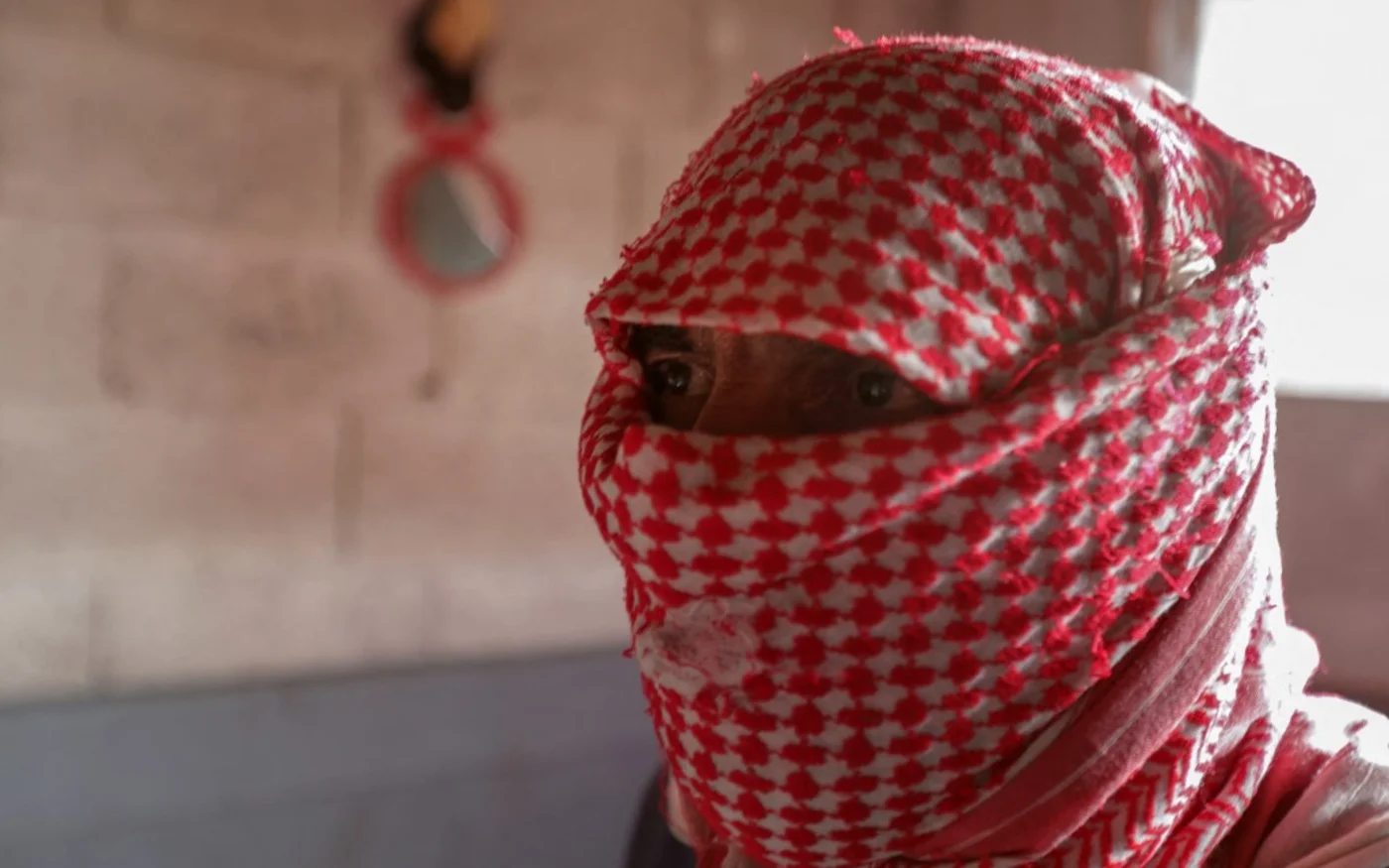 Un revendeur masqué de Captagon est assis pour une interview dans la ville d’Alep, dans le nord de la Syrie, le 26 avril 2022 (AFP)