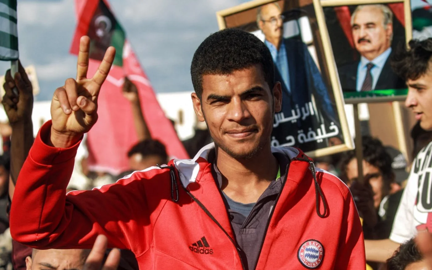 Pendant un discours du chef militaire Khalifa Haftar dans l’est de la Libye, un de ses partisans fait le V de la victoire lors d’un rassemblement marquant le 71e anniversaire de l’indépendance du pays, à Benghazi, le 24 décembre 2022 (AFP)