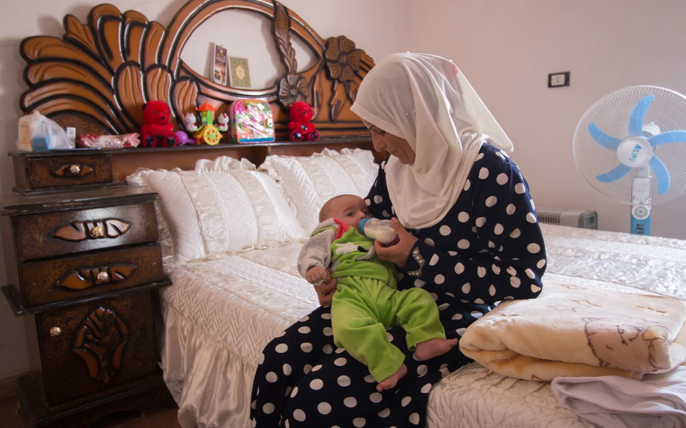 L’épouse d’Adel Hamam nourrit l’enfant qu’elle parraine avec son mari dans leur maison du village de Kafr Houm, à l’ouest d’Idleb, le 11&nbsp;octobre&nbsp;2021 (MEE)