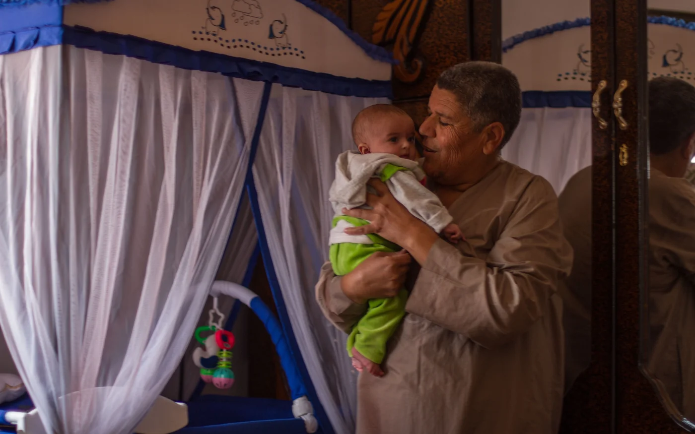 Adel Hamam porte l’enfant qu’il parraine et joue avec lui dans sa maison du village de Kafr Houm, à l’ouest d’Idleb, le 11&nbsp;octobre&nbsp;2021 (MEE)