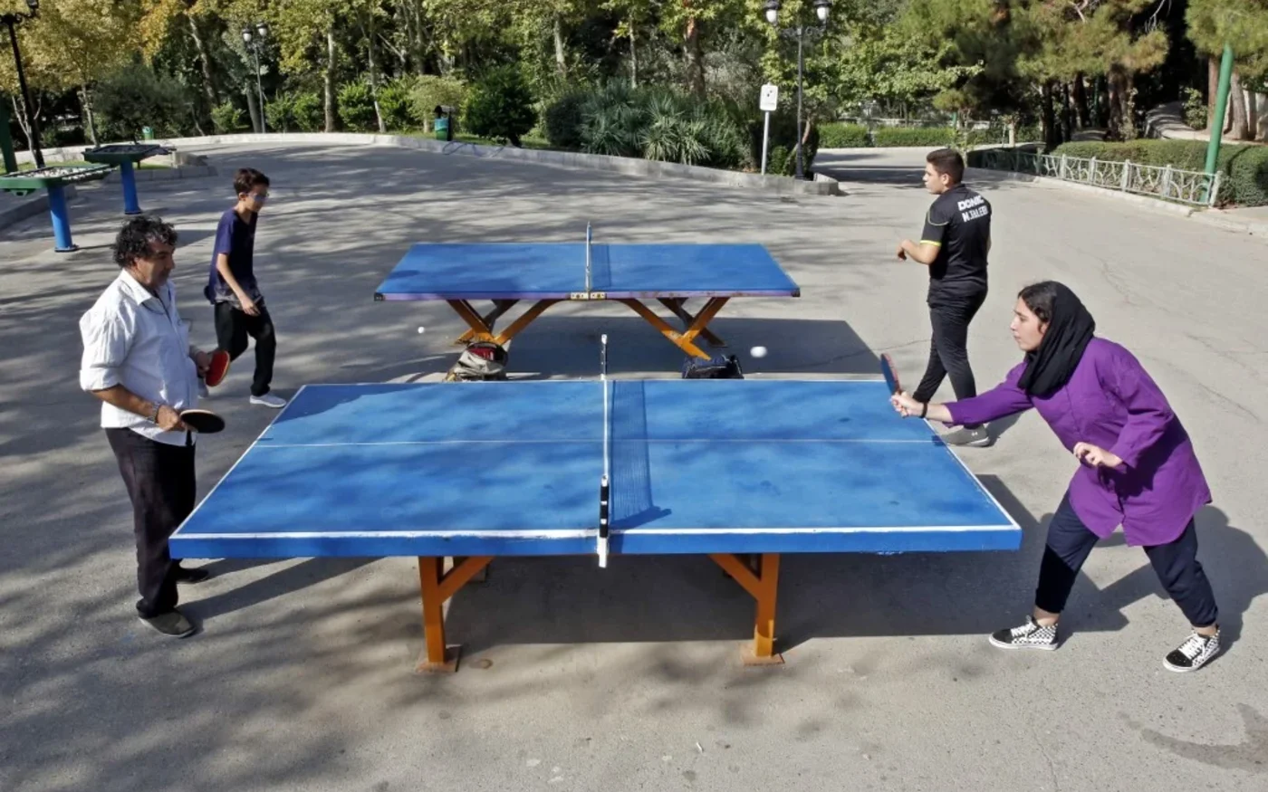 Des Iraniens jouent au tennis de table dans un parc de Téhéran, le 10 septembre 2021 (AFP)