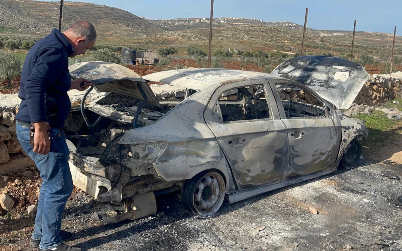 Un Palestinien inspecte une voiture vandalisée par des colons israéliens dans le village palestinien de Jalud, au sud-est de Naplouse, le 30 janvier 2023 (MEE/Amir Halmi Shaheen)