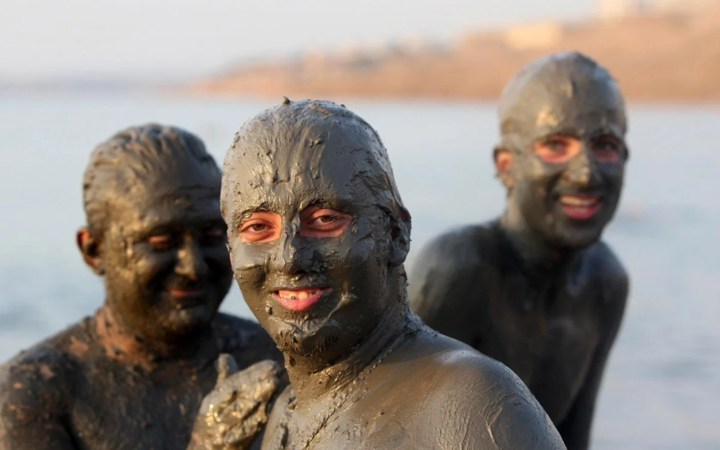 Des Jordaniens couverts de boue profitent d’une journée dans le complexe de Shuneh sur la mer Morte (AFP)