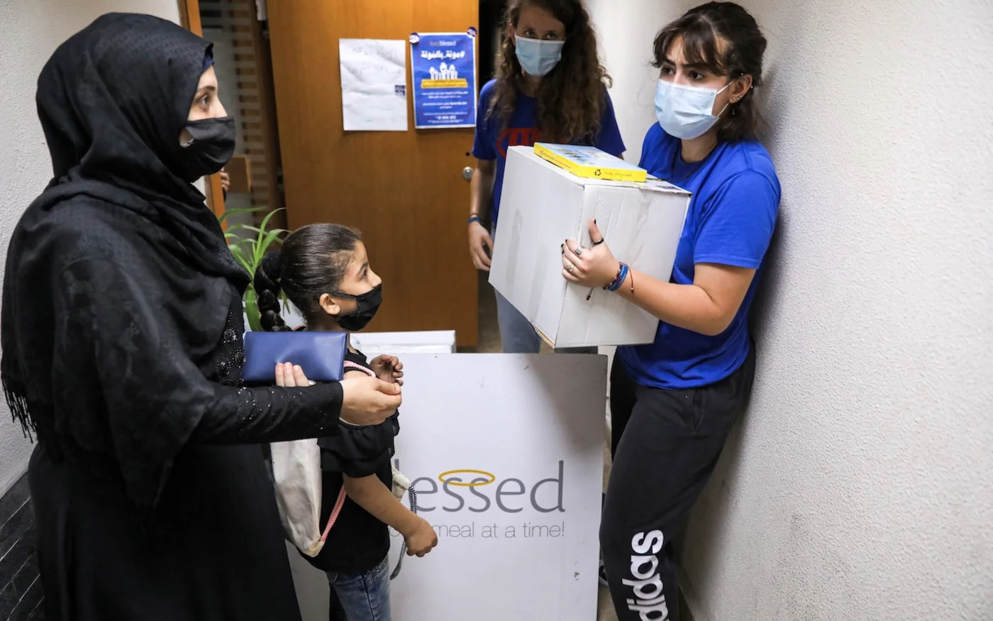 Distribution des colis d’aide alimentaire de la part de travailleurs, au centre de l’ONG Food Blessed à Beyrouth, le 28 juillet 2020 