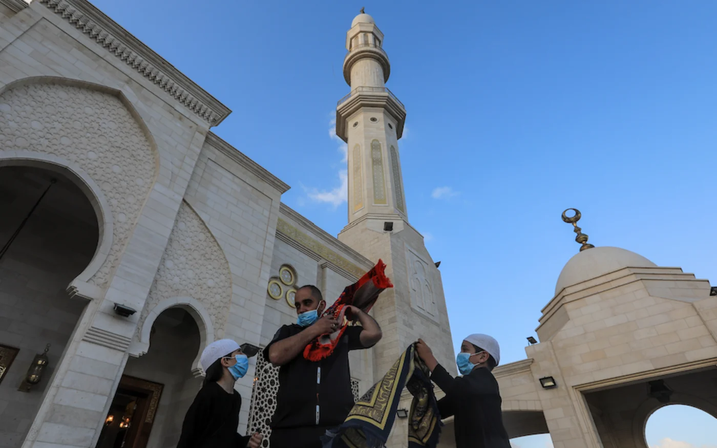 Une famille palestinienne quitte une mosquée après avoir accompli la prière de l'Aïd al-Fitr, à Gaza, le 24 mai 2020 (AFP)