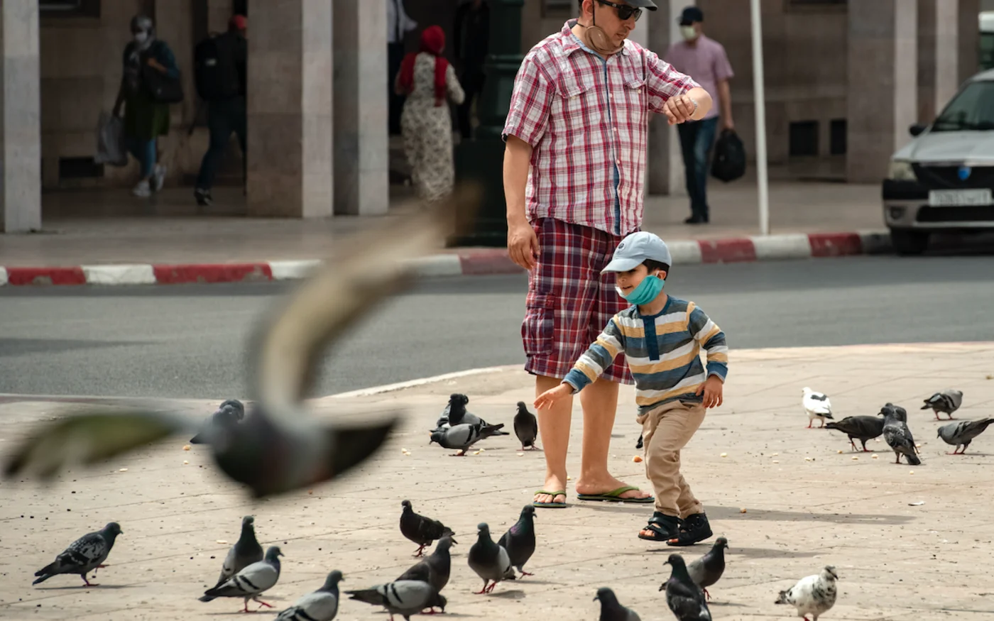 Un enfant portant un masque, court après des pigeons, à Rabat, le 16 juin 2020 (AFP)