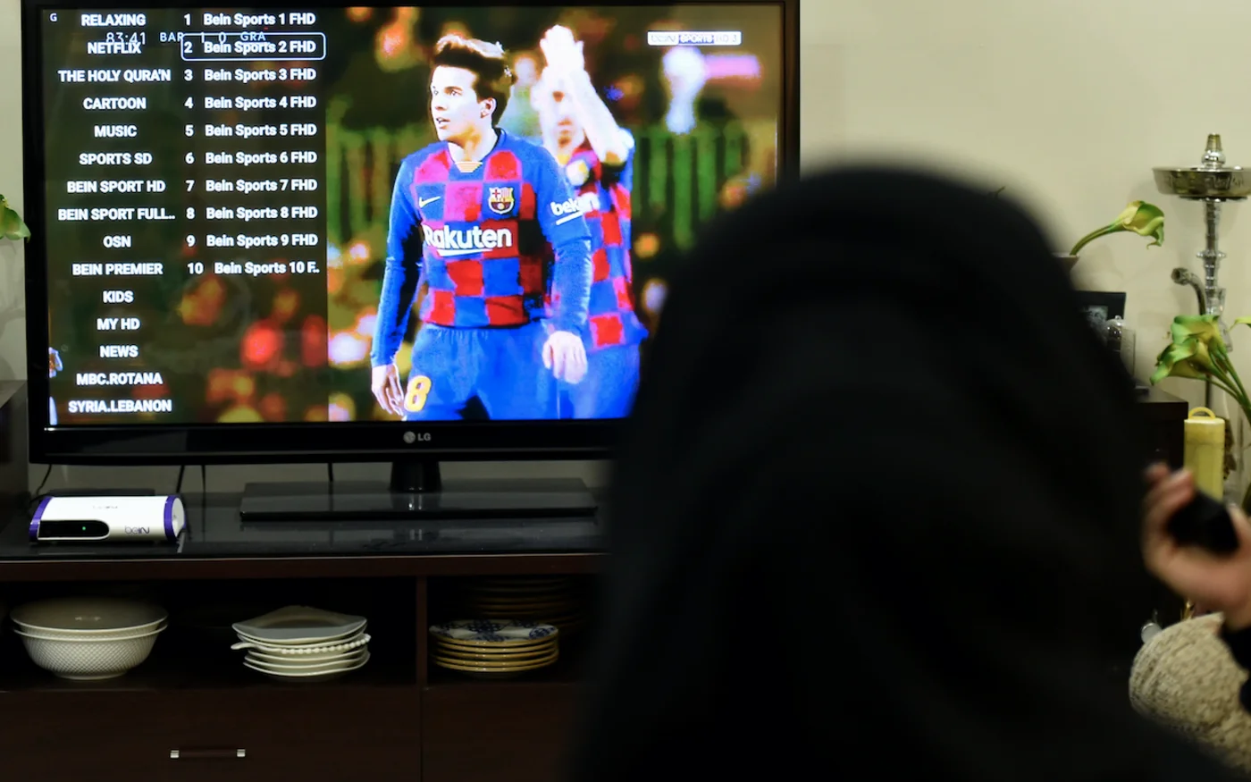 Une photo montre des membres d'une famille saoudienne regardant la chaîne sportive beIN du Qatar, à Riyad, le 20 janvier 2020 (AFP)