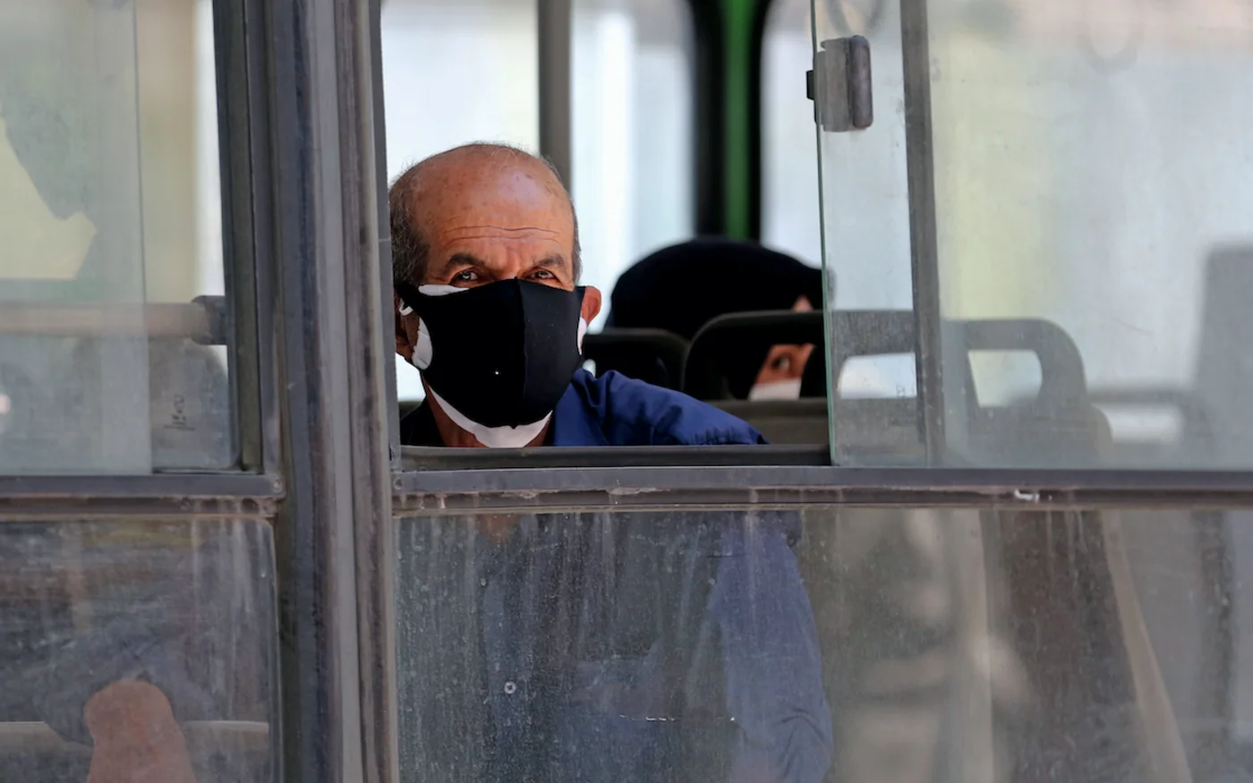 Un homme regarde par la fenêtre d'un bus dans la capitale iranienne, Téhéran, le 22 juin 2020 (AFP)