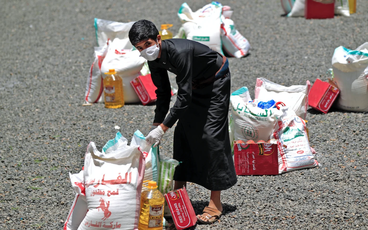 Un jeune Yéménite transporte un colis alimentaire, à Sanaa, le 17 mai 2020 (AFP)