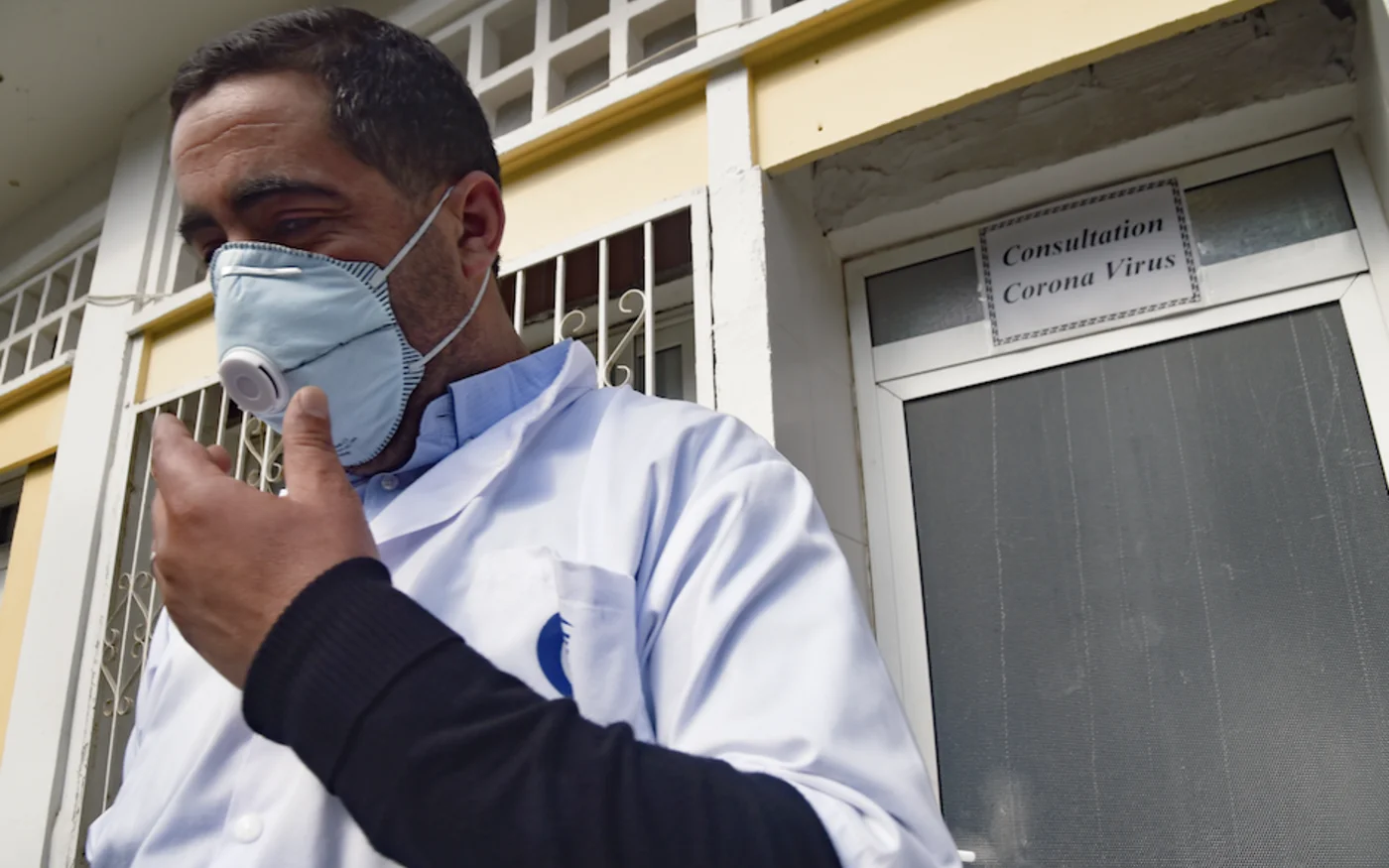 Un médecin algérien pose son masque de protection devant l'unité spéciale de l'hôpital El-Kettar, à Alger, le 26 février 2020 (AFP)