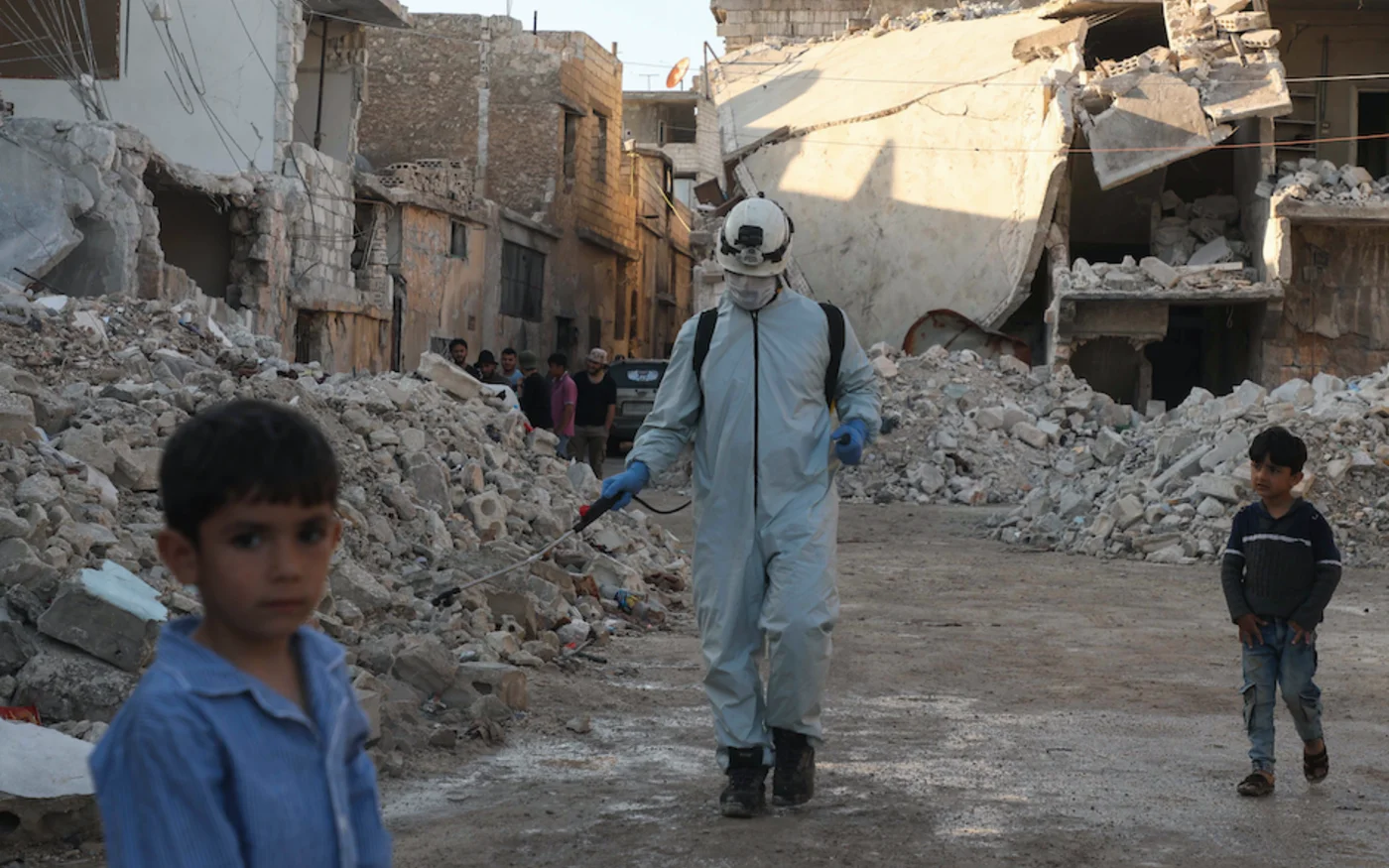 Un membre de la défense civile syrienne désinfecte un quartier détruit, à Alep, le 7 mai 2020 (AFP)