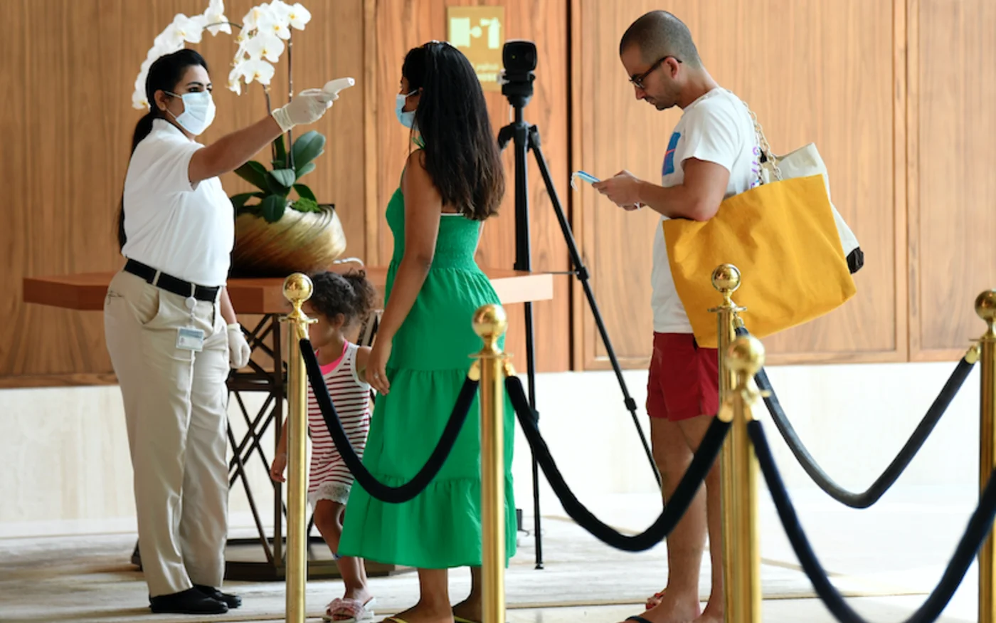 Un membre du personnel vérifie la température d'un touriste, à Dubaï, le 9 juillet 2020 (AFP)