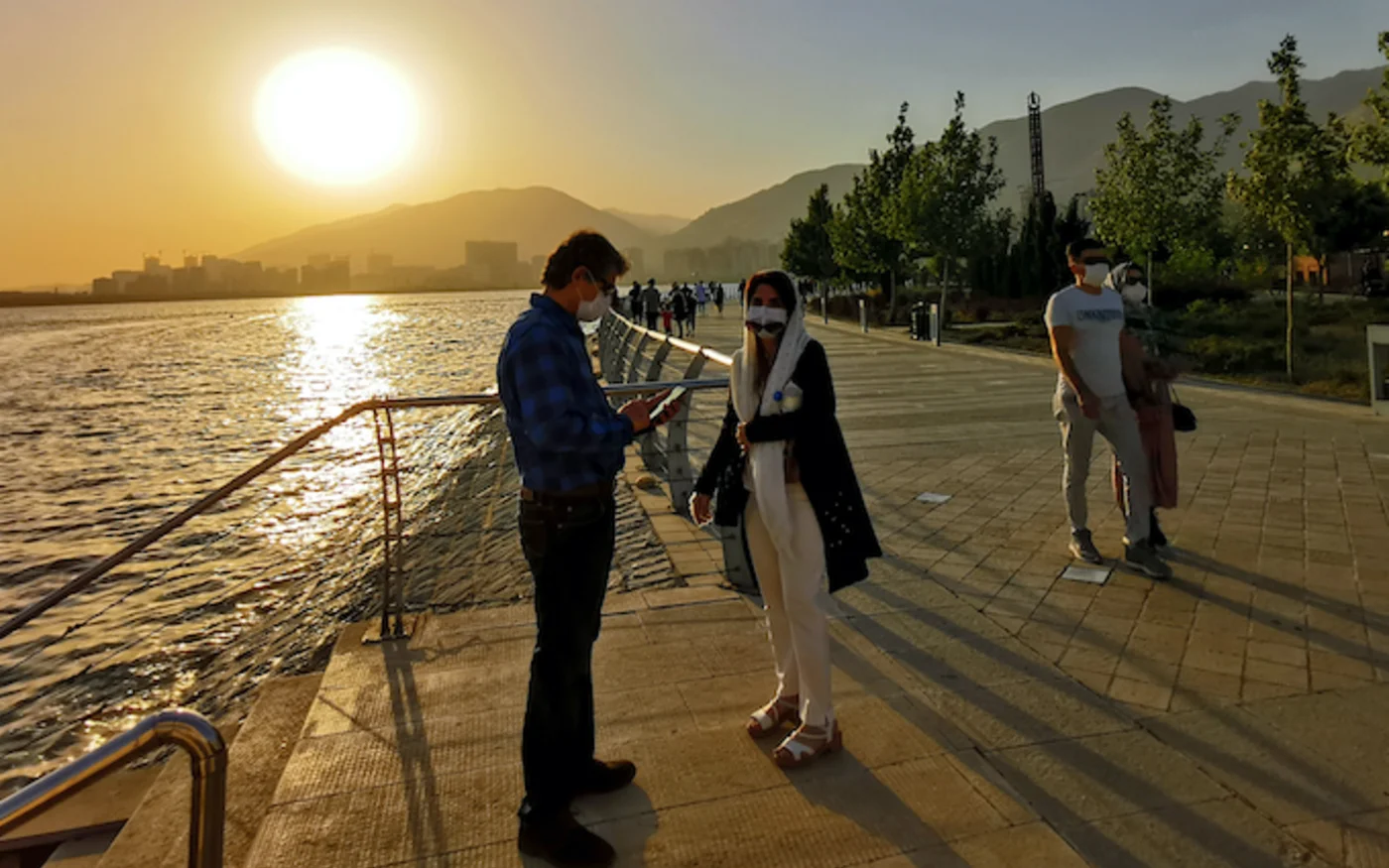 Des Iraniens se promènent le long du lac artificiel de Chitgar, à Téhéran, le 3 juillet 2020 (AFP)